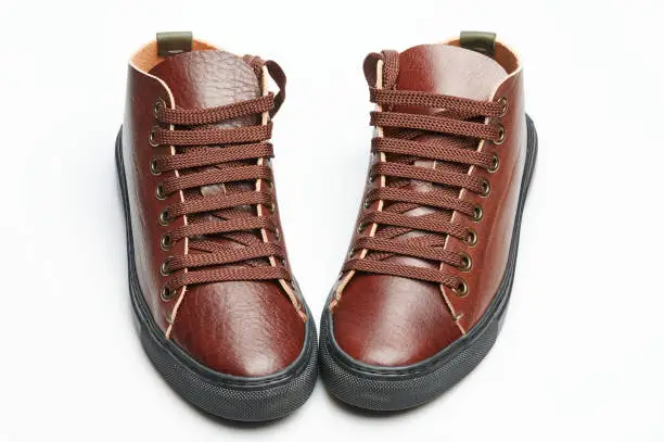 Photo of Front view of pair brown leather sneakers