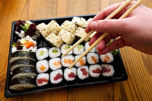 takeaway assortment of sushi rolls in a plastic box