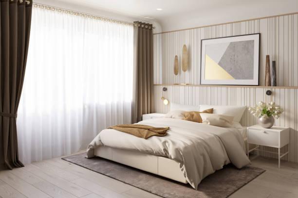 istock Modern bedroom with brown curtains on a large window, a horizontal poster on the headboard, a vase of tulips on the nightstand, knitted pillows on the double bed, carpet on the wooden floor. 1351115808