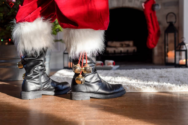 nahaufnahme der stiefel des weihnachtsmanns vor einem kamin - nikolaus stiefel stock-fotos und bilder