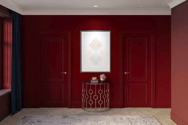 istock Dark burgundy hall with a vertical poster above an elegant console between the doors, dark curtain near the window, light carpet on the parquet floor, built-in lamps in the white ceiling. 1351119581