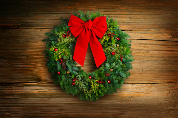 istock Christmas Wreath Hanging On Old Weathered Planks 1351121352