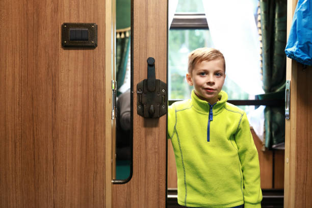 istock Boy in doorway of train compartment 1351124594