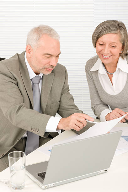 istock Happy senior businesspeople looking graphs 135112569