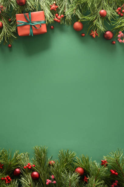 Christmas frame with red gift, pine branches and red balls. Xmas greeting card.