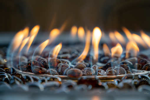 Close Up Of An Outdoor Fire Pit With Tempered Blue Fire Glass With Blue And Yellow Flames