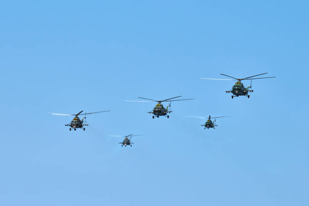 helicópteros militares voando no céu azul realizando voo de demonstração, equipe acrobática, show aéreo - fighter plane airplane teamwork air force - fotografias e filmes do acervo