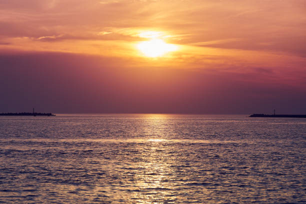 Calm sea with sunset sky, beautiful panoramic view. Amazing dramatic sunset sky with variety of colors and hues of rising sun and reflection in water. Meditation ocean, romantic tranquil seascape