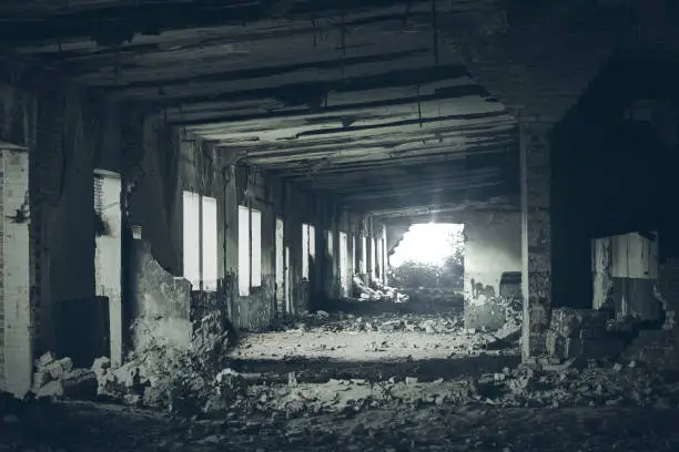 Photo of Abandoned building interior, ruins of industrial factory, dark corridor in scary abandoned premises