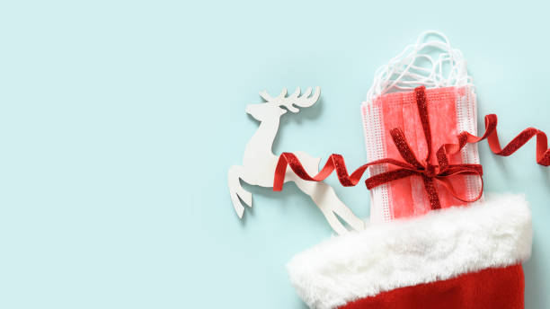 istock Christmas Santa hat with protective medical face mask and evergreen pine branches. 1351133882