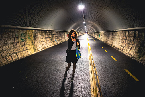 Adult Woman talking on smart phone in a tunnel