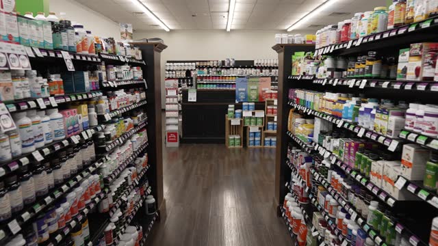 Moving down a store aisle with supplements and vitamins in a health foods market