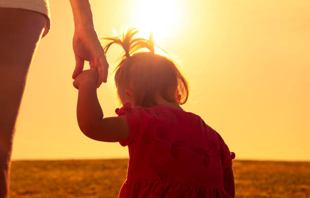istock Mother and daughter walking together at sunset. 1351146220
