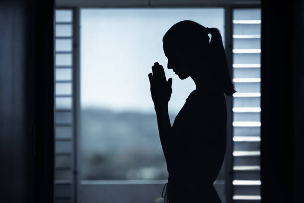 istock Woman praying at home. 1351146247