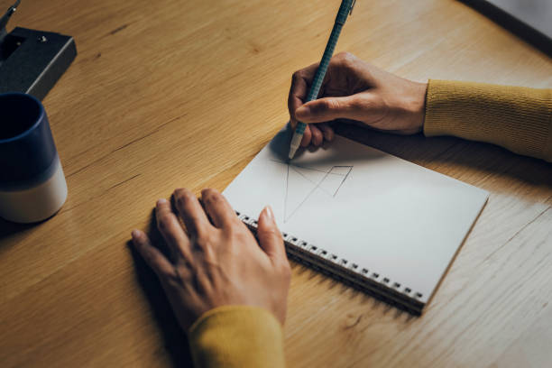 istock Close Up of Woman Hands Drawing Something in a Notebook 1351146406