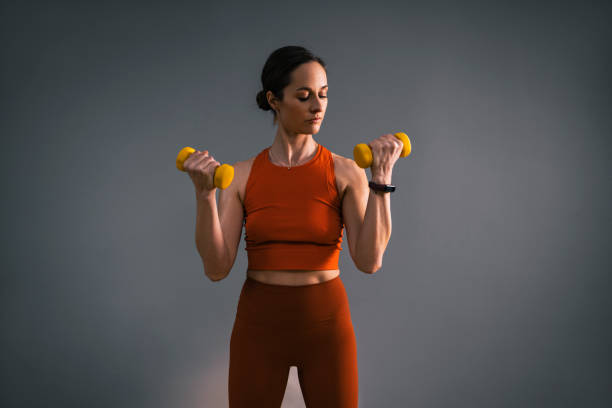 istock Serious Woman Exercising with Hand Weights in Gym 1351147697