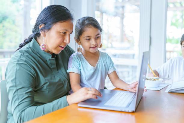 Mom working from home with homeschooled children stock photo