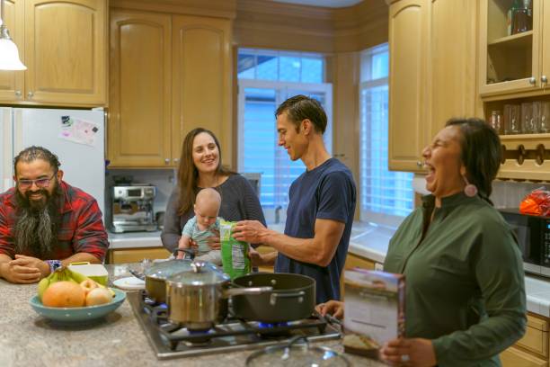 grupo multiétnico de familiares e amigos preparando jantar de ação de graças juntos - native american baby love mother - fotografias e filmes do acervo