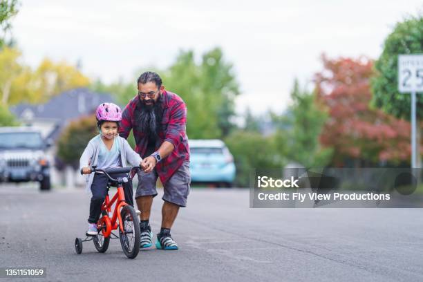 Native American Dad Helping His Young Daughter Learn To Ride A Bike Stock Photo - Download Image Now