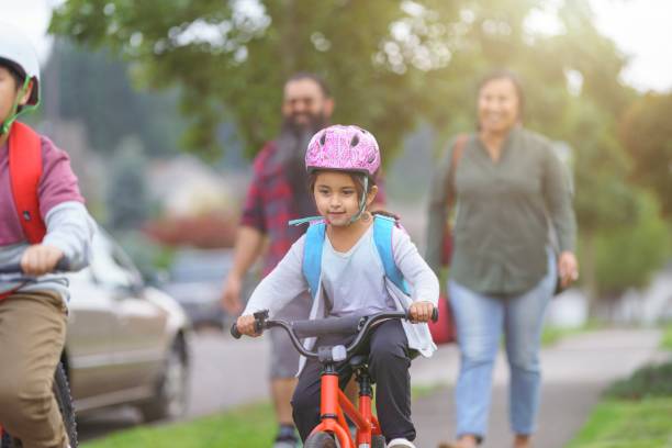 Environmentally conscious family commuting by bike and foot stock photo