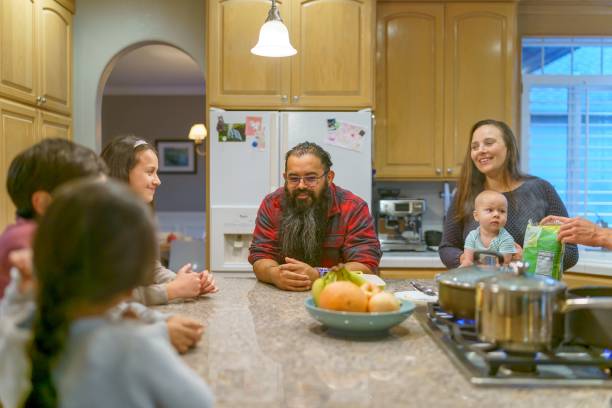multiethnische gruppe von familie und freunden bereitet gemeinsam thanksgiving-abendessen vor - domestic life mother baby multi ethnic group stock-fotos und bilder