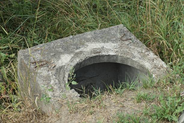 istock gray concrete slab of sewer with an open hatch 1351151777