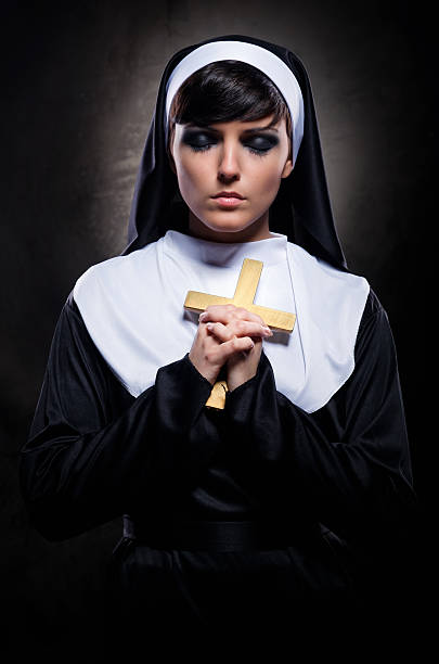 istock Young attractive nun holding a cross 135115427
