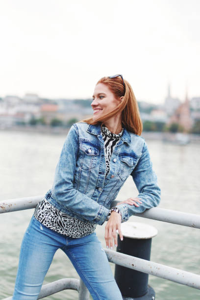 istock Young redhead cheerful woman posing at riverbank 1351154737