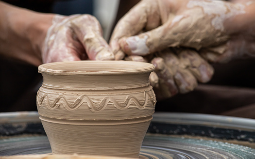 Female sculptor making clay mug in a home workshop,hands close-up.Small business,entrepreneurship,hobby, leisure concept.