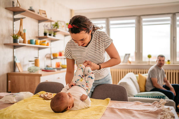 Mother changing her newborn baby at home