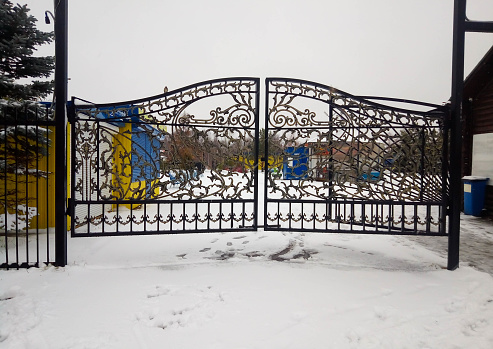Beautiful wrought iron gates on a snowy winter day.
