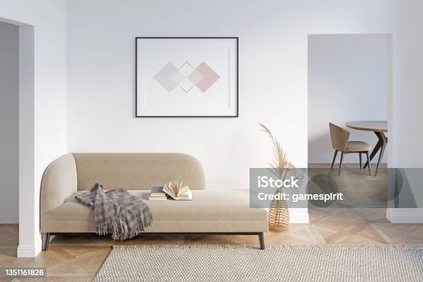 A Bright Modern Hall With A Horizontal Poster Above A Beige Couch With A Warm Blanket And An Open Book Dried Flowers In A Wicker Vase Two Doorways A Dining Table In The Background Stock Photo - Download Image Now