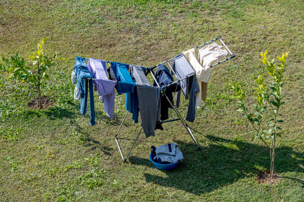 The washed clothes on the clothes rack are drying in the garden on a sunny day.