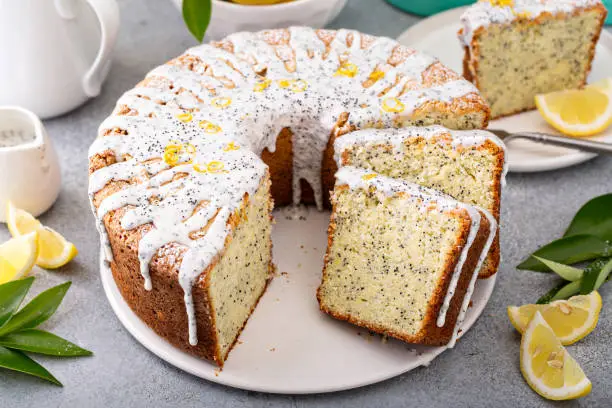 Lemon Poppy Seed Bundt Cake with powdered sugar glaze. A slice of cake on a plate.