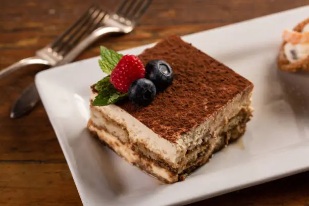 Traditional italian desserts, tiramisu and cannoli on the table