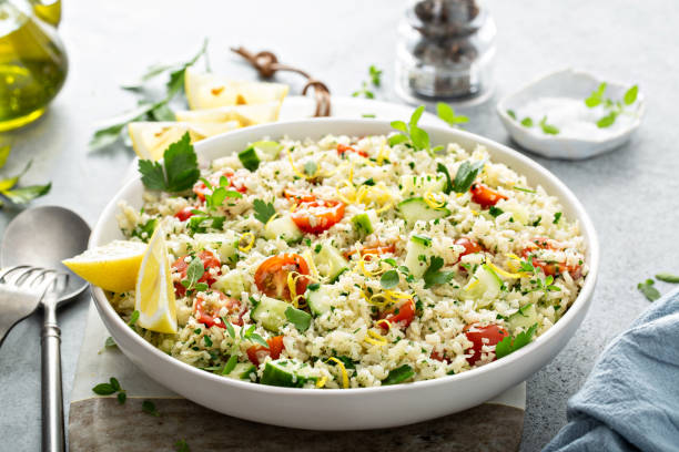 Tabbouleh salad with cauliflower rice and vegetables Tabbouleh salad with cauliflower rice, herbs and vegetables, low carb alternative recipe cous cous stock pictures, royalty-free photos & images