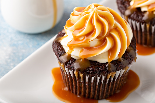 Chocolate cupcake with cream cheese frosting and caramel syrup