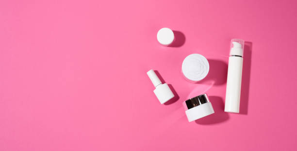 istock nail polish, jar and empty white plastic tubes for cosmetics on a pink background. Packaging for cream, gel, serum, advertising and product promotion 1351170183