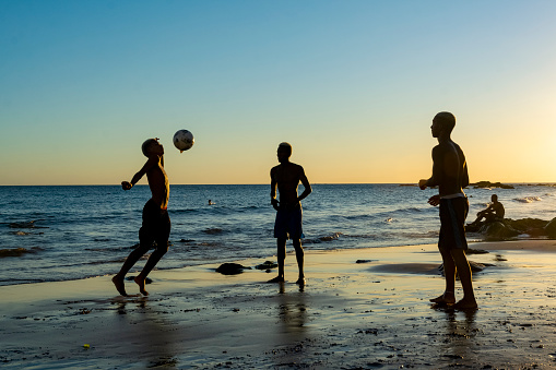 Salvador, Bahia, Brazil - January 08, 2020: Young people playing sand football at sunset on Ondina beach in Salvador, Bahia, Brazil.