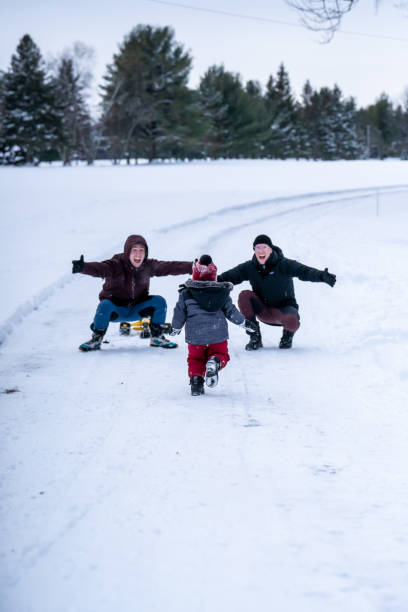 family playing outside during winter. - foto’s van jongen stockfoto's en -beelden