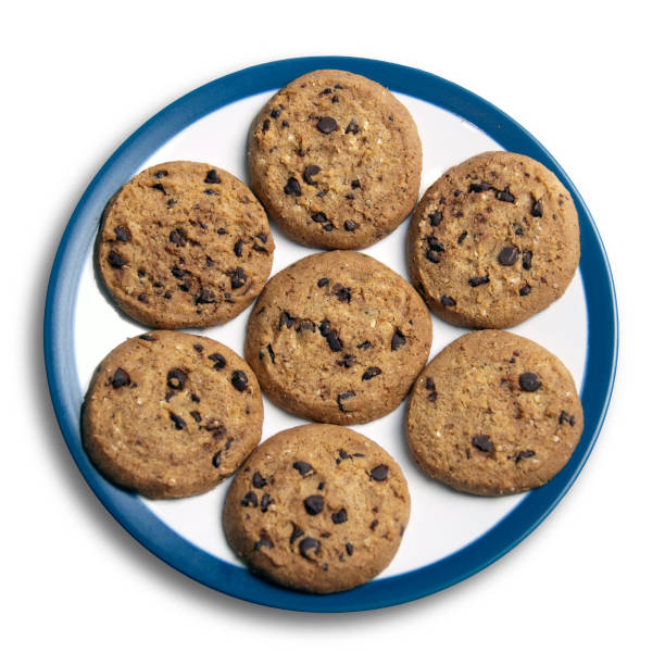 Tasty cookies with chocolate chips and coffee on a light kitchen table, selective focus.