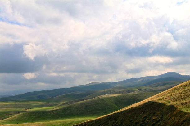 istock overcast clouds cloudscape sky lush green rainy rolling mountain hills landscape background 1351180820
