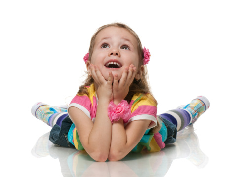 A smiling little girl is looking up; isolated on the white background