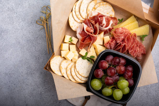 Cheese and charcuterie board to go in a box Cheese and charcuterie board to go in a box, take out concept charcuterie stock pictures, royalty-free photos & images