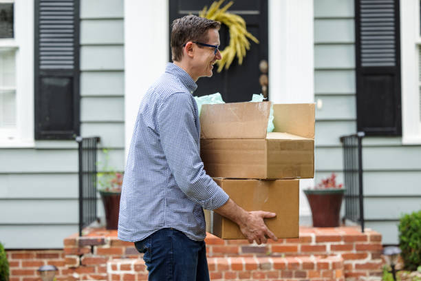 istock A man and father holding moving boxes outside a small blue cottage house getting ready to move into his new house 1351183196