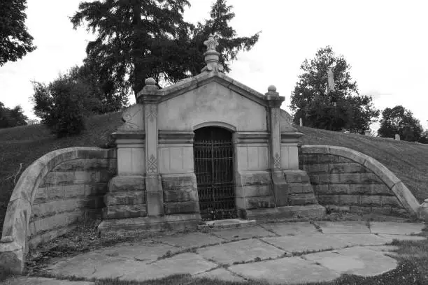 a large old cemetery tomb crypt burial chamber monument graveyard black white spooky vintage architectural background