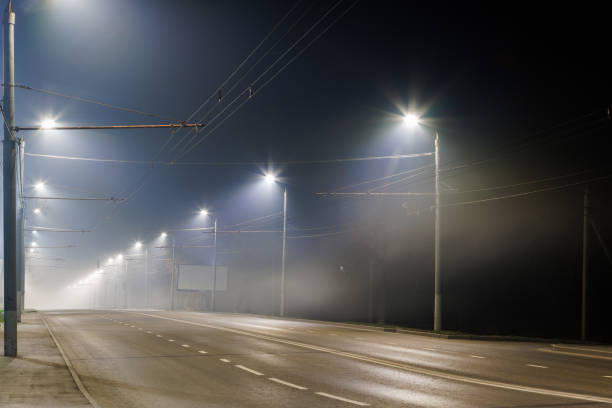 istock empty foggy night road with rows of lamp posts 1351193956