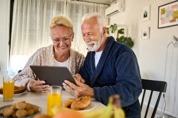 istock Older couple looking at digital tablet over breakfast at home 1351194964