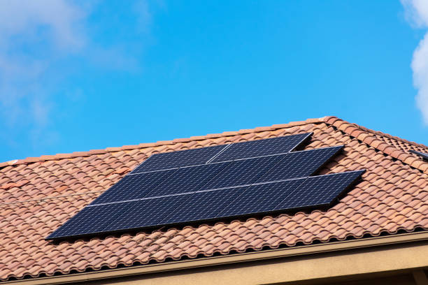 istock Solar panels installed on the tile roof. Blue sky. 1351197925