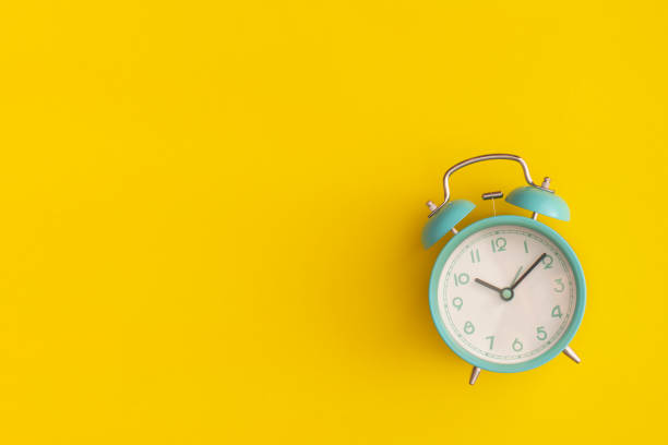 istock Blue alarm clock on yellow background. Top view with copy space. Flat lay. Back to school concept. 1351198604